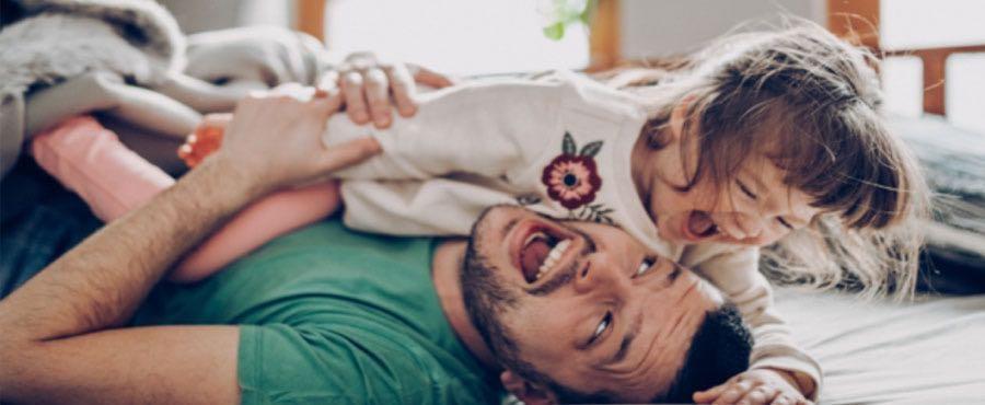 Padre jugando y sonriendo con su hija